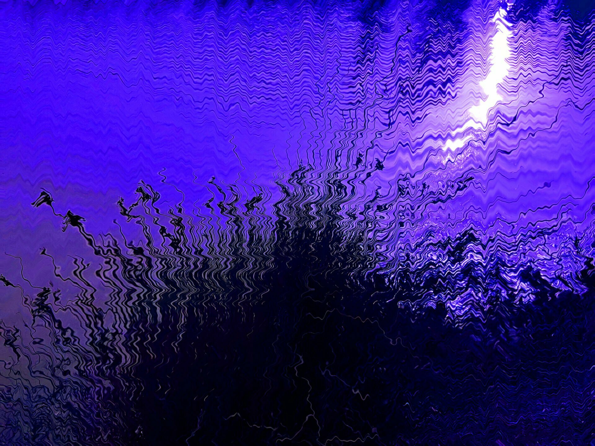 From blu-violet darkness to light abstract image with dark fluid shape and a shining burst of light on dominant bright blue-violet colours liquid background