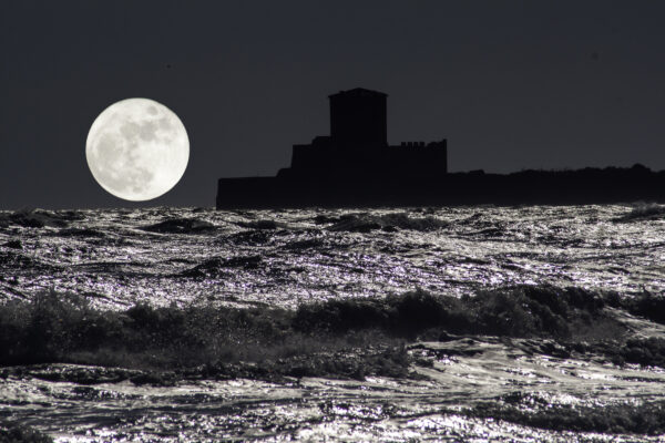 night sea with fortress moon and moonlight reflections on waves