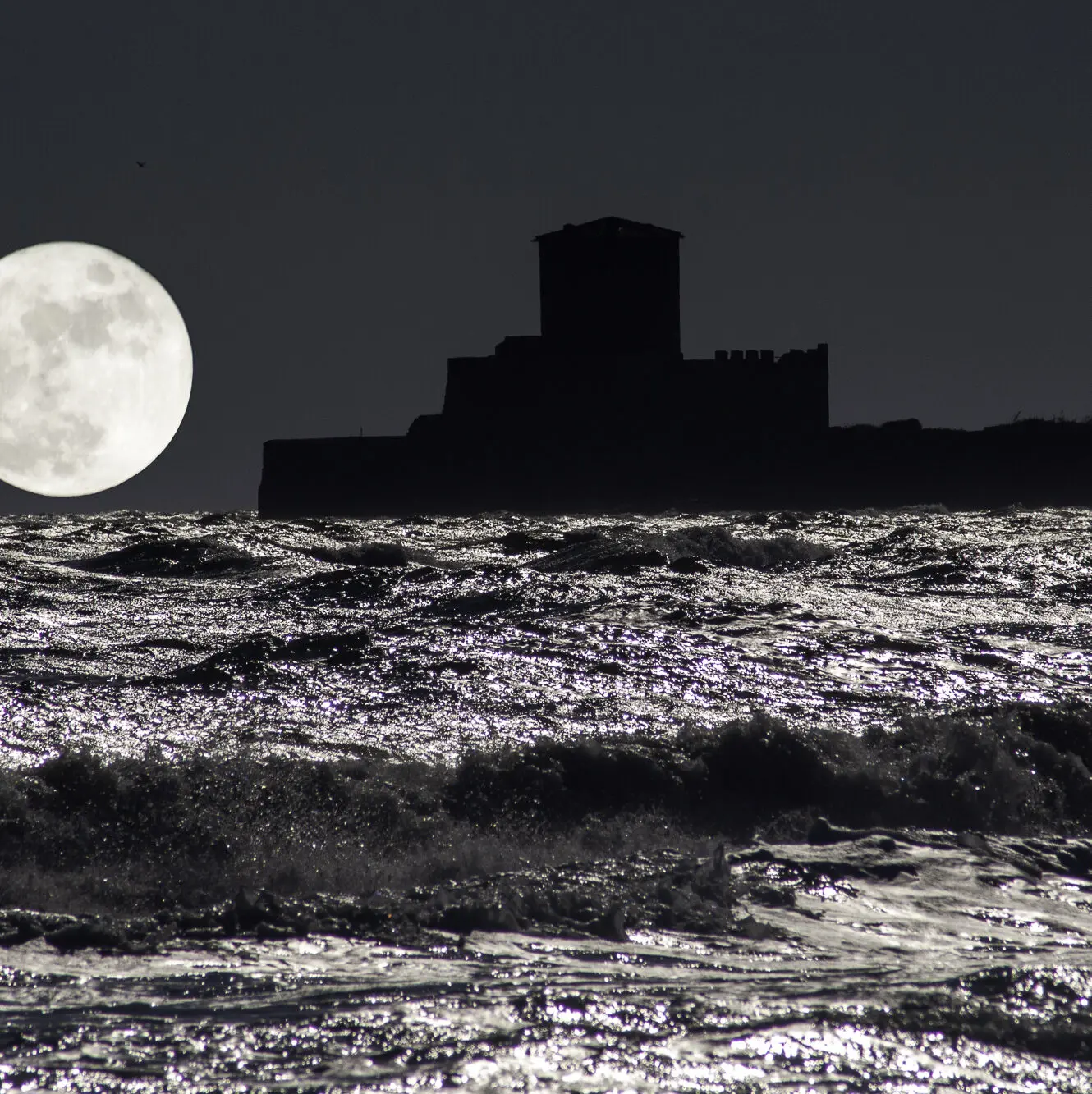 night sea with fortress moon and moonlight reflections on waves